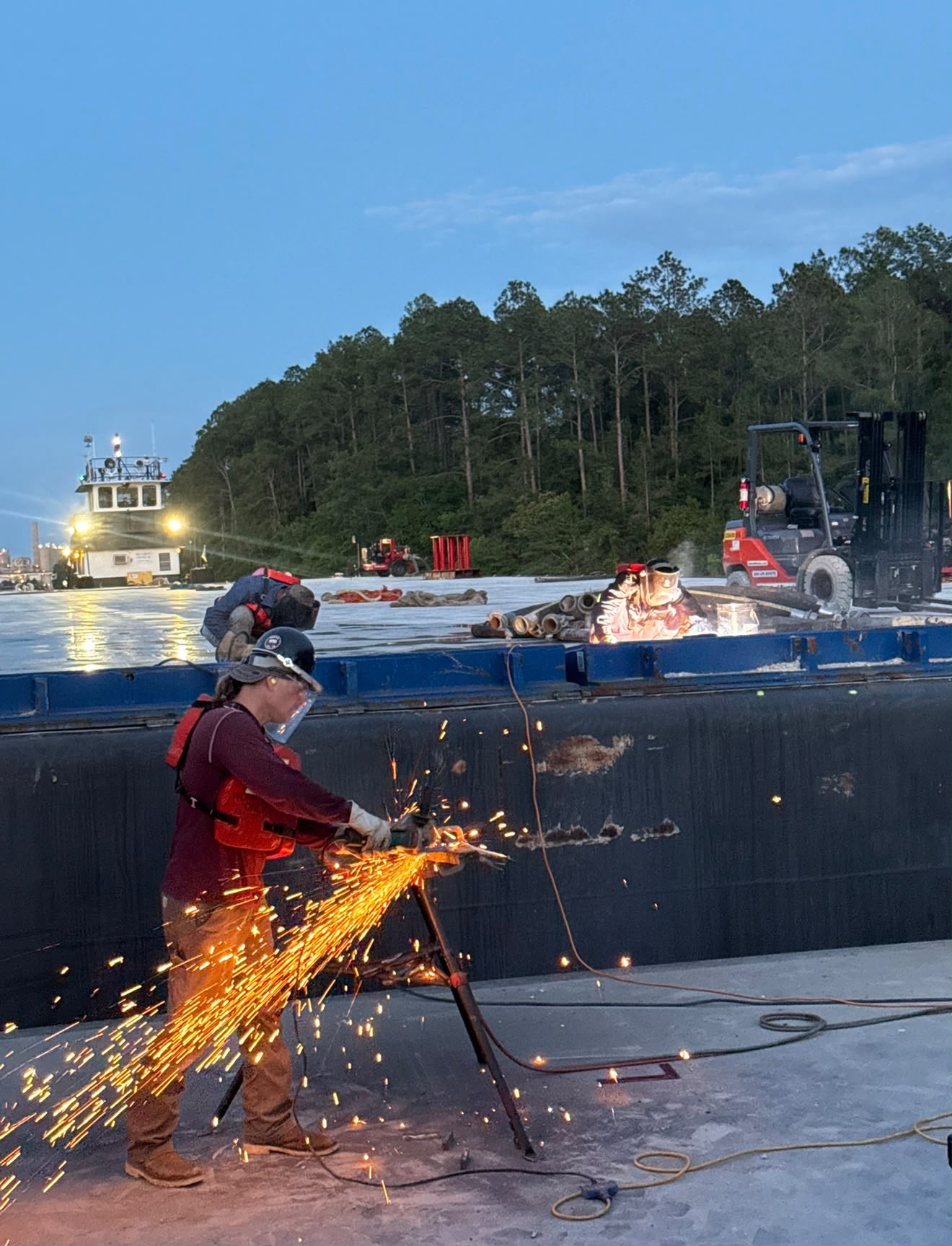 Field crew welding and preparing a barge for transport