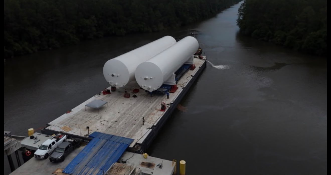 Large cylindrical tanks secured on a transport barge